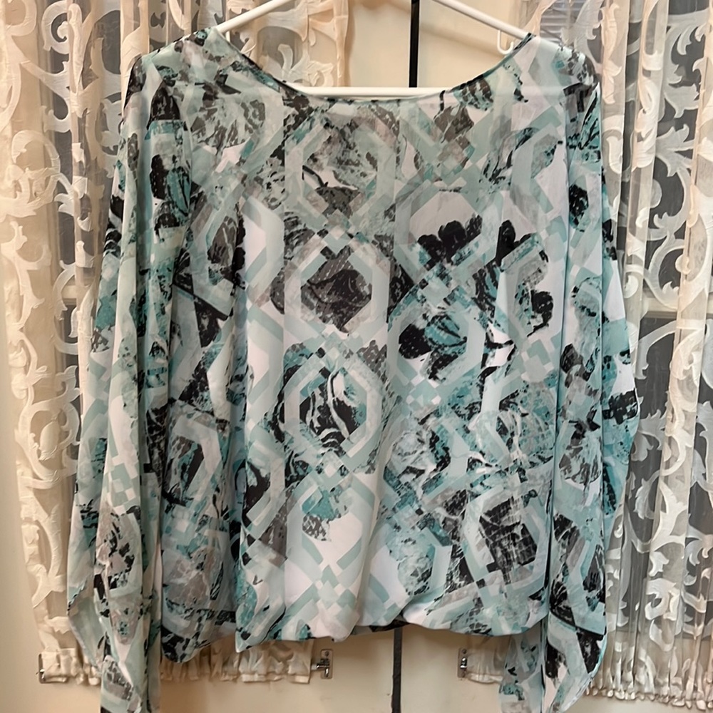 Patterned top with bubble hemline, built in tank and asymmetrical sleeves
